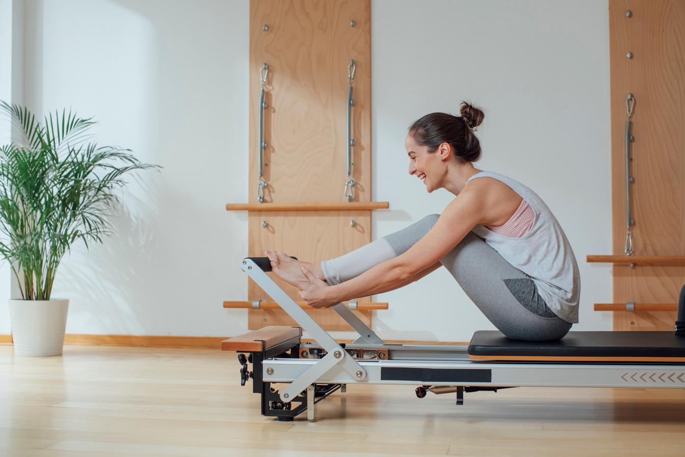 Sportswoman Doing Exercise on Pilates Reformer