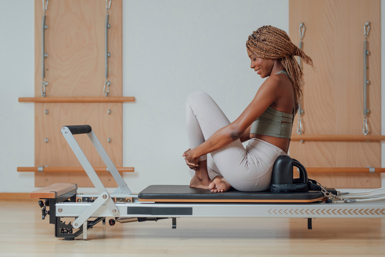 Sportswoman Sitting on Pilates reformer